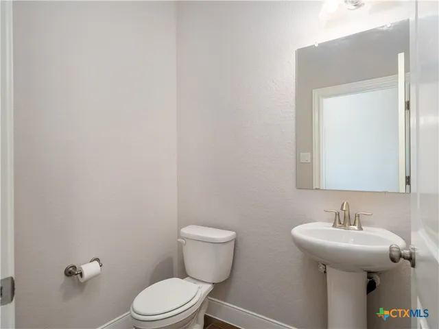 a bathroom with a toilet a sink and mirror
