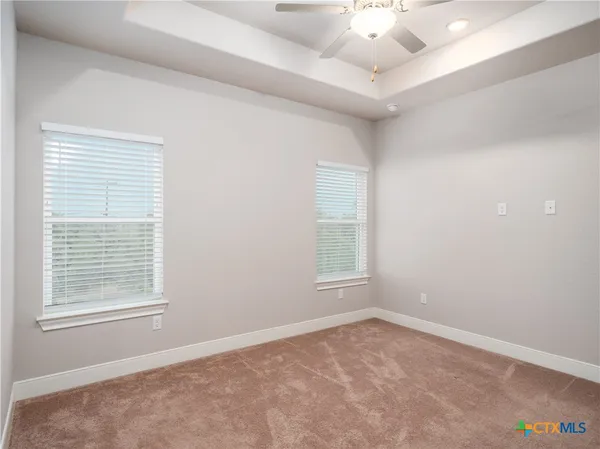 an empty room with a window and a ceiling fan