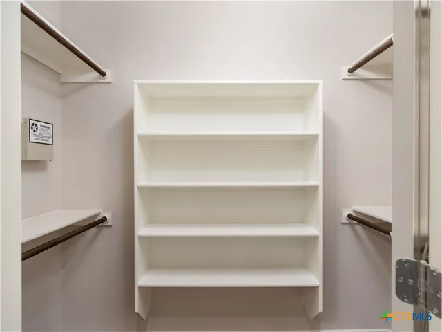 a view of walk in closet with empty racks