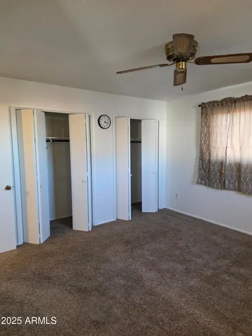 an empty room with fan and windows