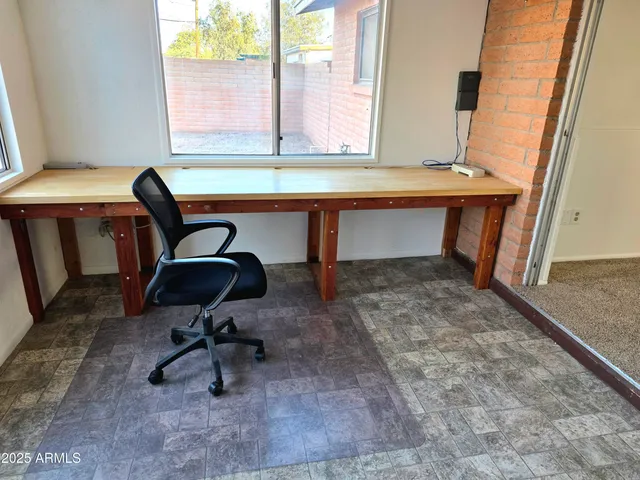 a view of a workspace with furniture and window
