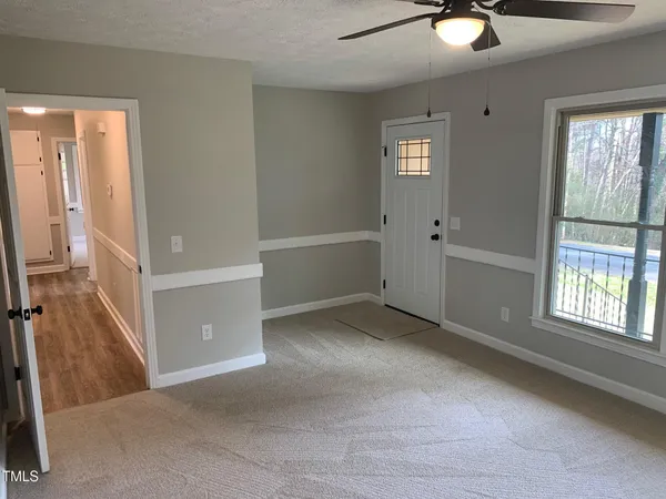 a view of an empty room with window and cabinet