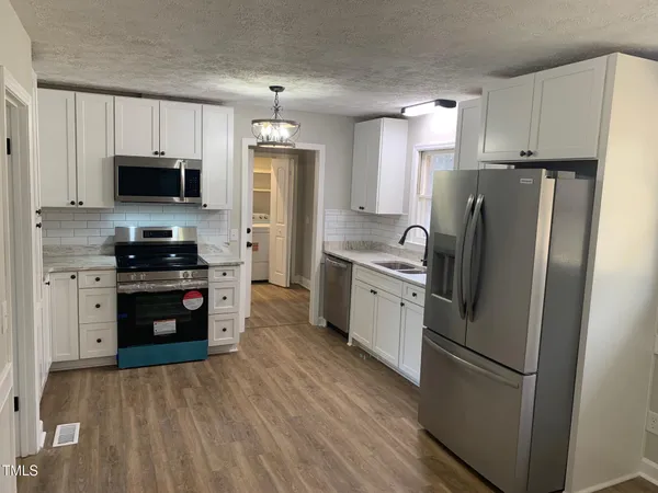 a kitchen with stainless steel appliances a refrigerator stove and microwave