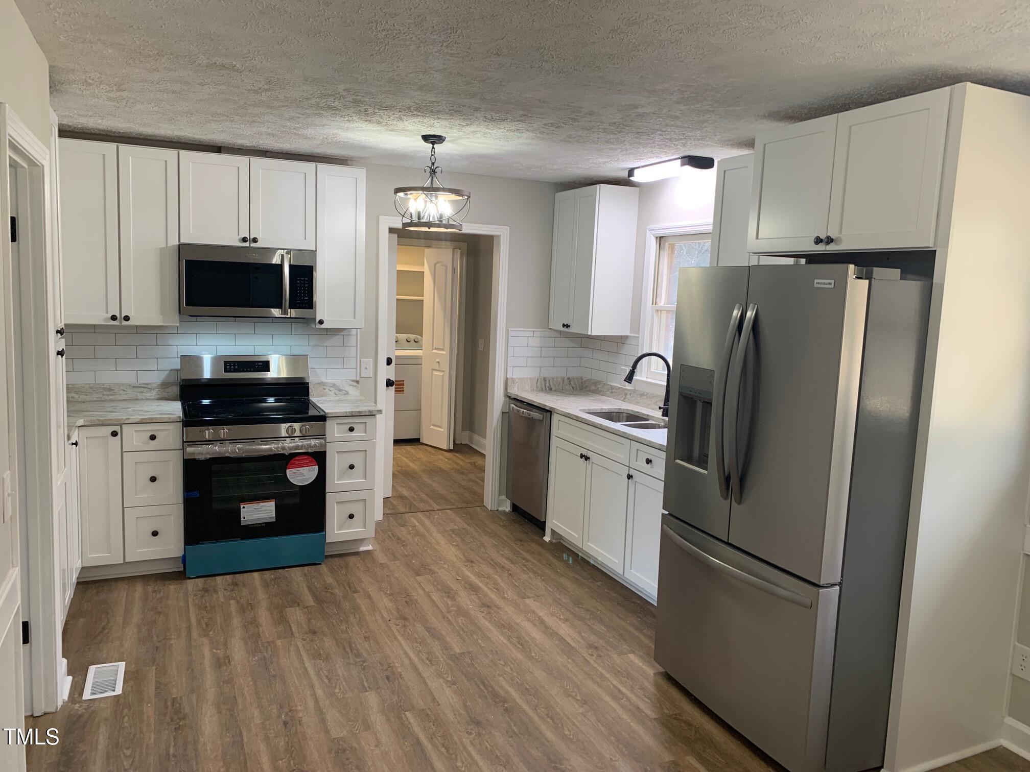 209 Reade Drive Roxboro, NC 27573 - Photo 6 of 19 a kitchen with stainless steel appliances a refrigerator stove and microwave