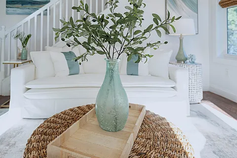 a living room with furniture kitchen view and a chandelier