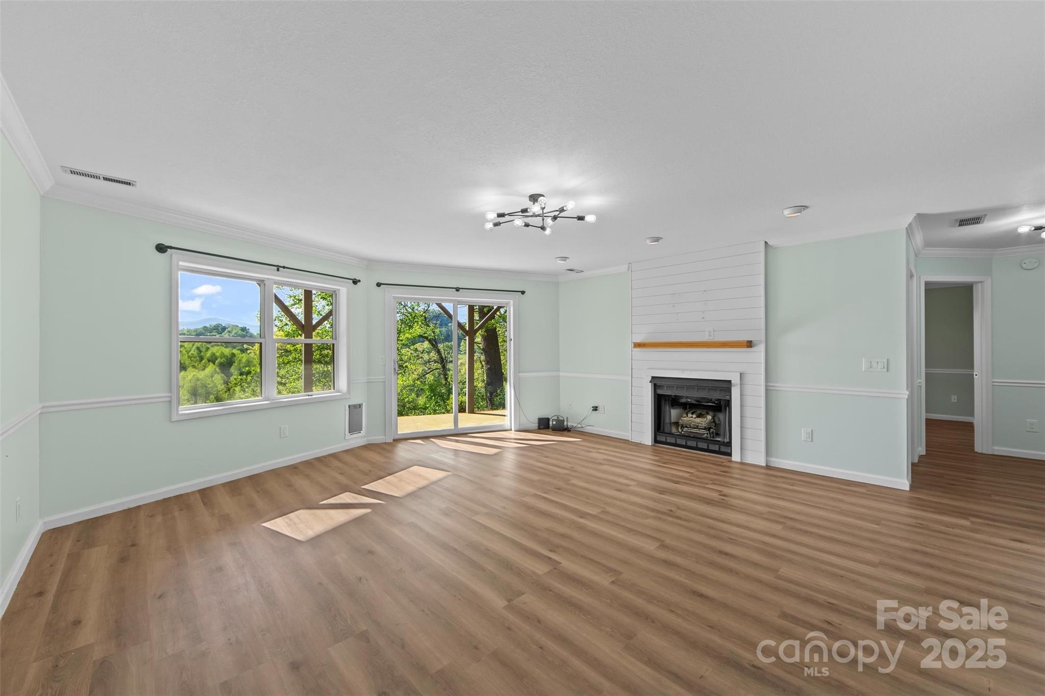 84 Halfmoon Way Clyde, NC 28721 - Photo 29 of 48 a view of an empty room with wooden floor fireplace and a window