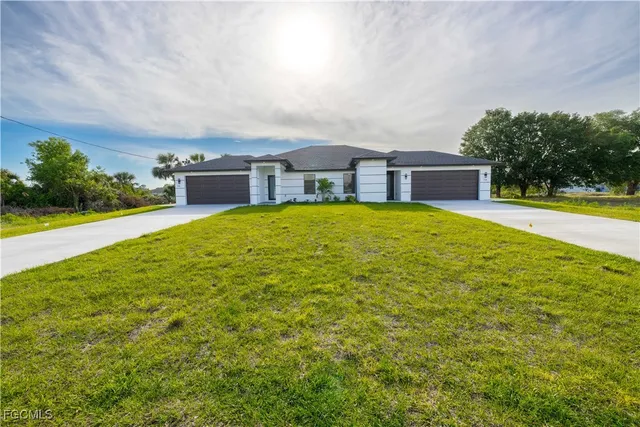 a view of a house with a yard and garage