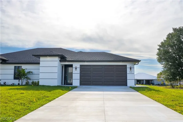 a front view of a house with a yard and garage