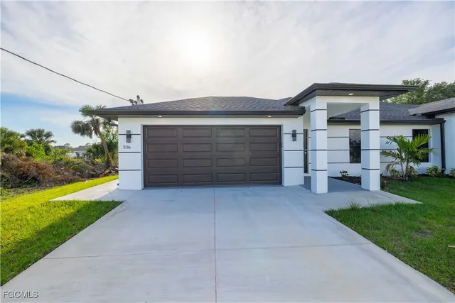 a front view of a house with yard and green space