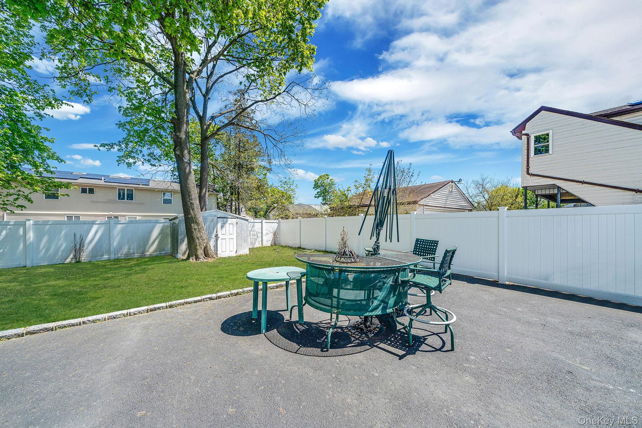 1169 Little E Neck Road West Babylon, NY 11704 - Photo 24 of 28 a view of a backyard with table and chairs and a fire pit