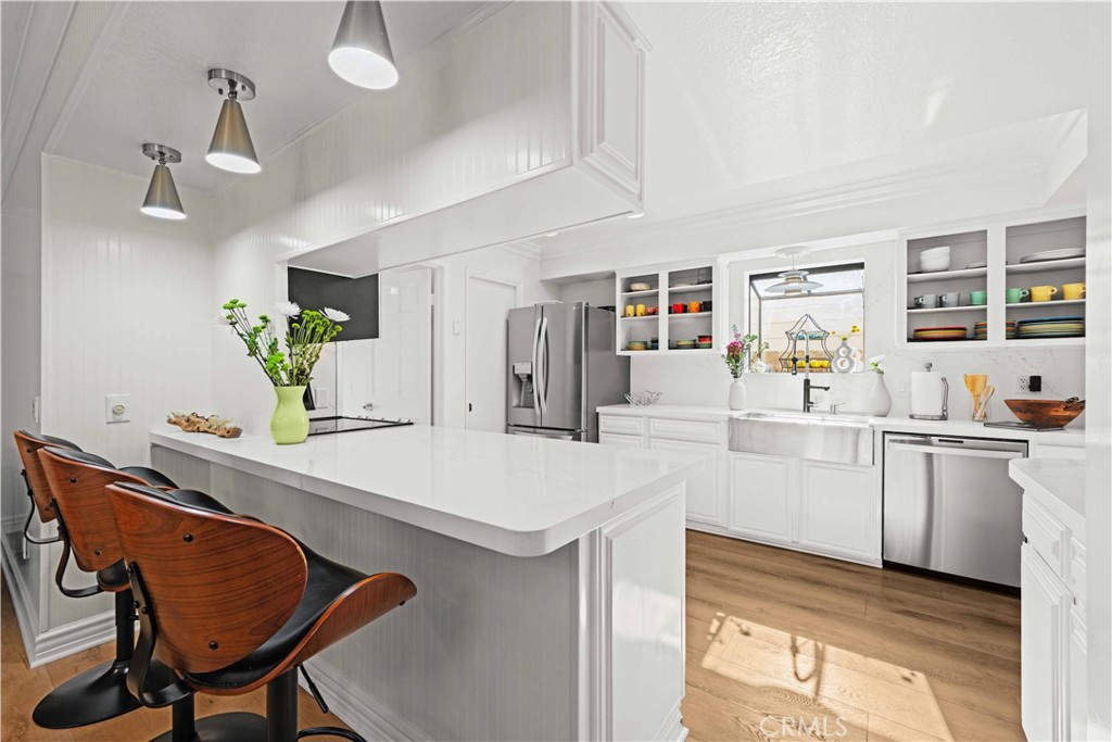 86 North Vía Di Roma Walk Long Beach, CA 90803 - Photo 15 of 42 a kitchen with stainless steel appliances kitchen island a table and chairs in it