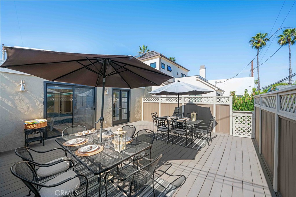86 North Vía Di Roma Walk Long Beach, CA 90803 - Photo 27 of 42 a view of a patio with table and chairs under an umbrella with potted plants