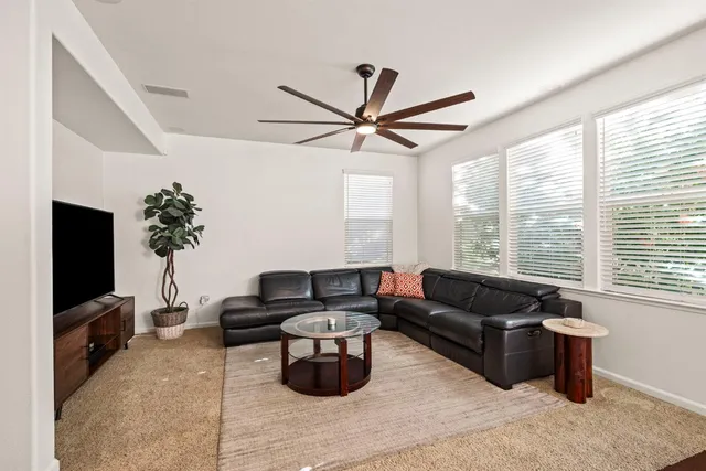 a living room with furniture a flat screen tv and a large window