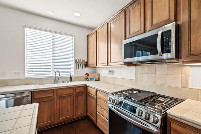 a kitchen with stainless steel appliances a stove sink microwave and cabinets