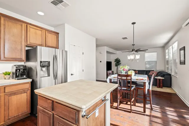 a kitchen with a table chairs refrigerator and cabinets