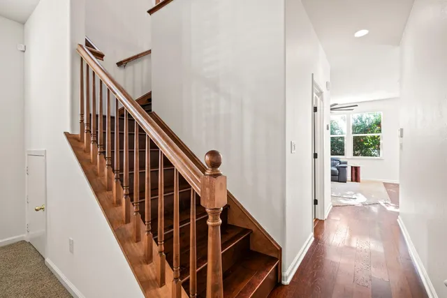 a view of a hallway with wooden floor and staircase