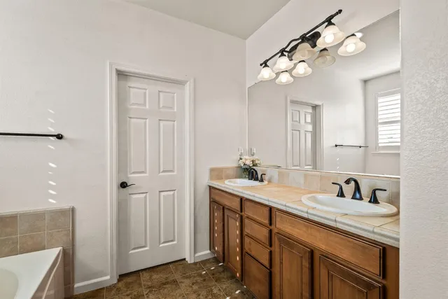 a bathroom with a sink a light fixture and a mirror