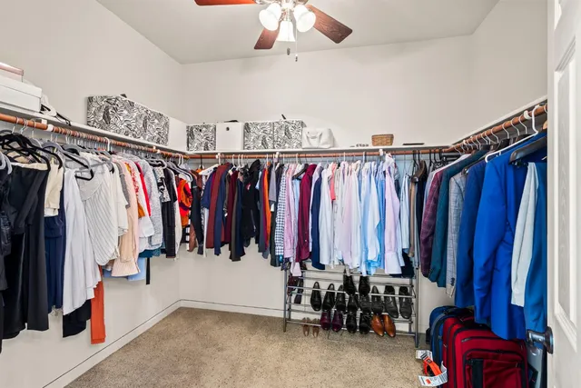 a view of walk in closet with clothes