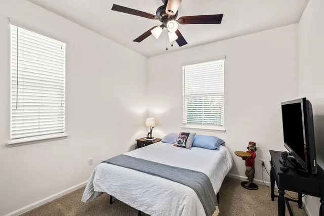 a bedroom with a bed tv and a window