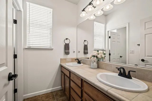 a bathroom with double vanity and a mirror