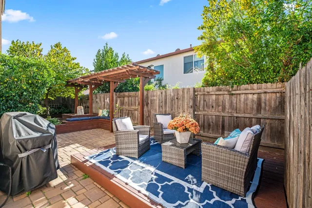 a backyard of a house with barbeque oven table and chairs