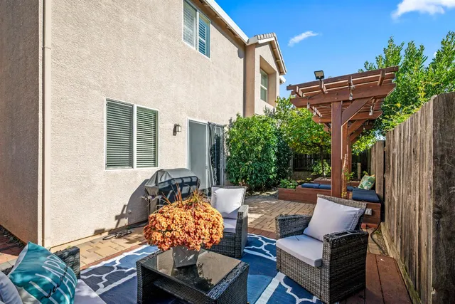 a backyard of a house with barbeque oven table and chairs