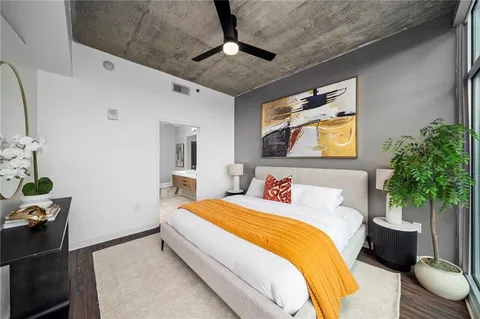 a bedroom with a bed and a potted plant