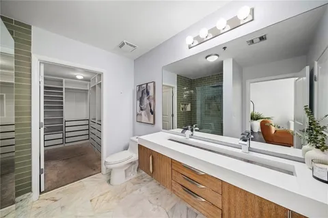 a spacious bathroom with a double vanity sink a large mirror and shower
