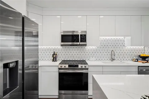 a kitchen with stainless steel appliances a stove a microwave and a refrigerator