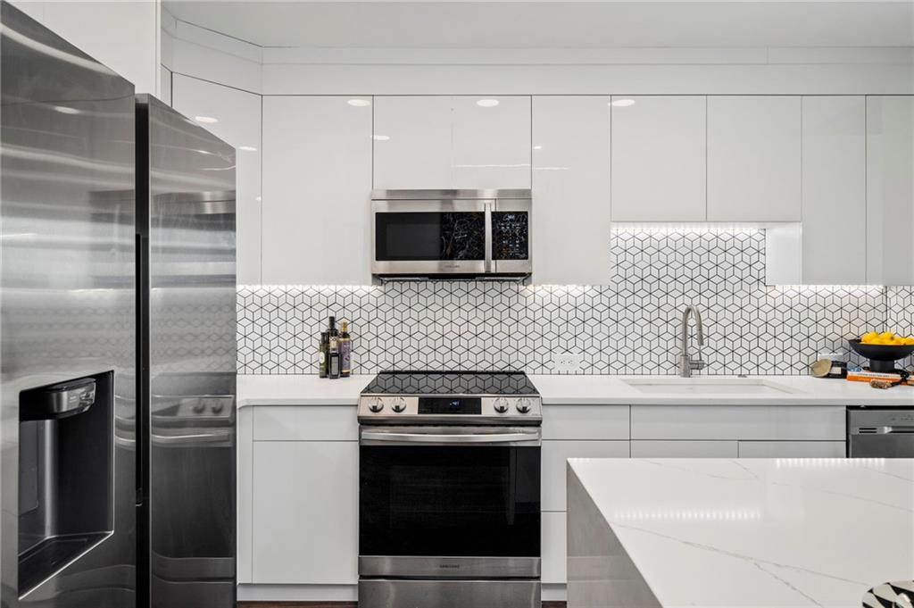 250 Pharr Road Northeast, Unit 1116 Atlanta, GA 30305 - Photo 6 of 45 a kitchen with stainless steel appliances a stove a microwave and a refrigerator