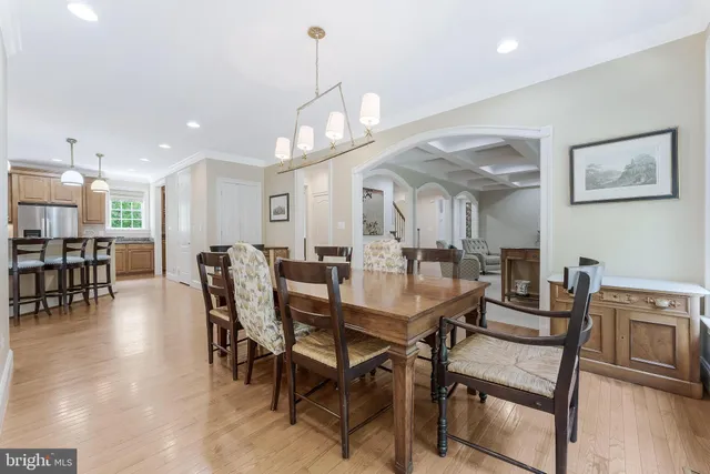 a view of a dining room and livingroom with furniture wooden floor a chandelier