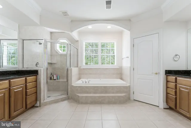 a spacious bedroom with a bed and a chandelier