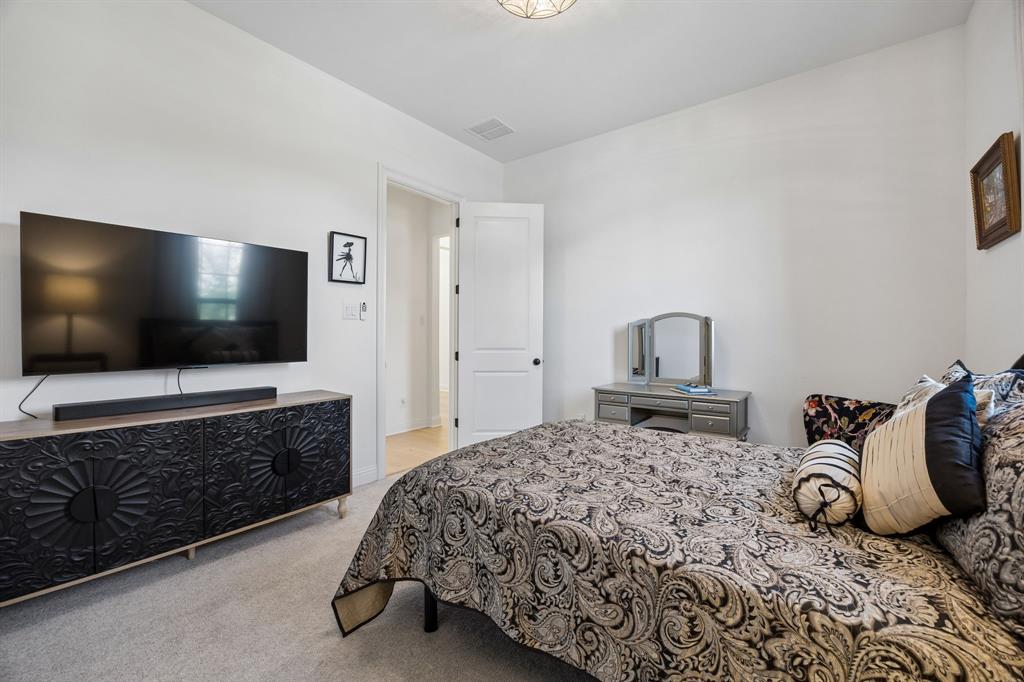 1717 Tolleson Drive Fort Worth, TX 76008 - Photo 22 of 40 a bedroom with a bed and a flat screen tv