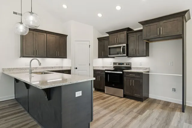 a kitchen with stainless steel appliances granite countertop a sink stove and refrigerator