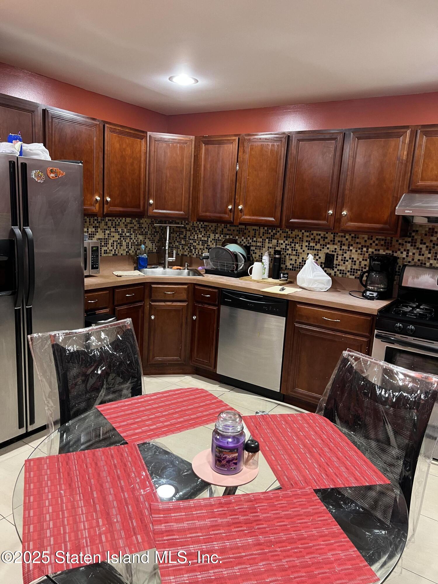 256 Maple Parkway Staten Island, NY 10303 - Photo 11 of 21 a kitchen with stainless steel appliances kitchen island granite countertop a sink dishwasher stove top oven and cabinets