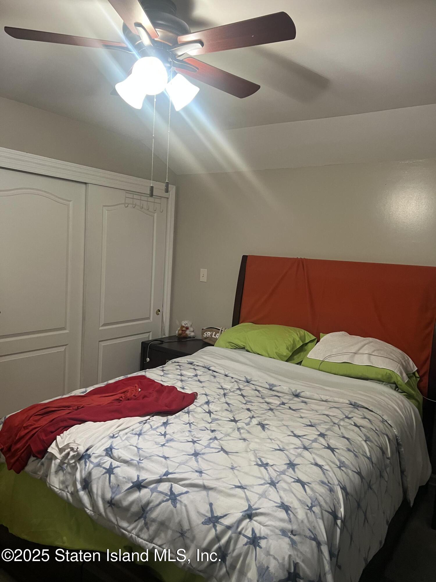 256 Maple Parkway Staten Island, NY 10303 - Photo 8 of 21 a bed sitting in a bedroom next to a window