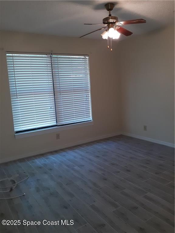 641 Barber Street Sebastian, FL 32958 - Photo 11 of 15 an empty room with wooden floor chandelier fan and windows