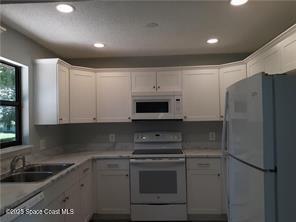 641 Barber Street Sebastian, FL 32958 - Photo 2 of 15 a kitchen with a refrigerator sink and cabinets