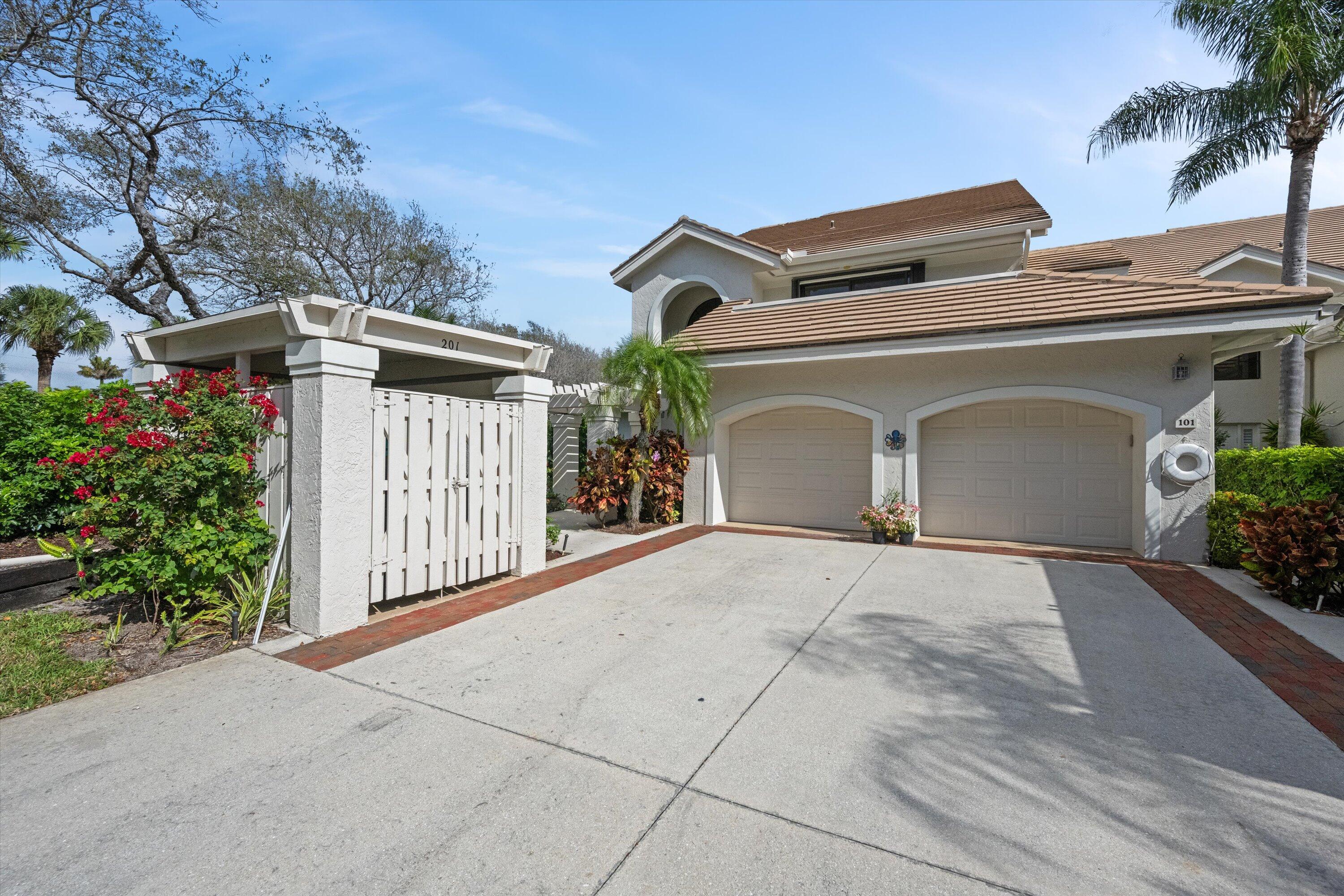 3971 Schooner Pointe Drive, Unit 201 Jupiter, FL 33477 - Photo 1 of 44 a view of a house with a yard and plants