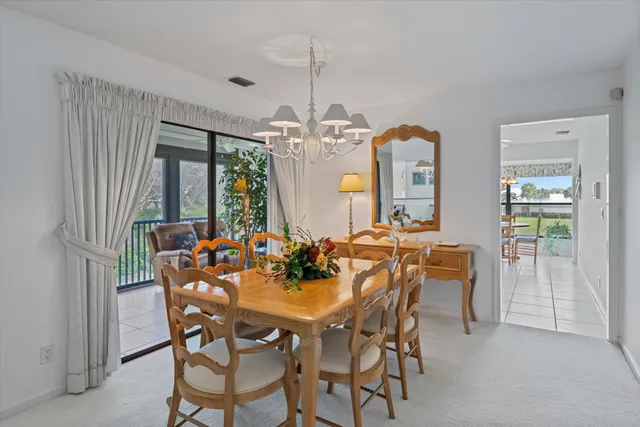 a kitchen with stainless steel appliances a stove top oven a sink a dining table and chairs