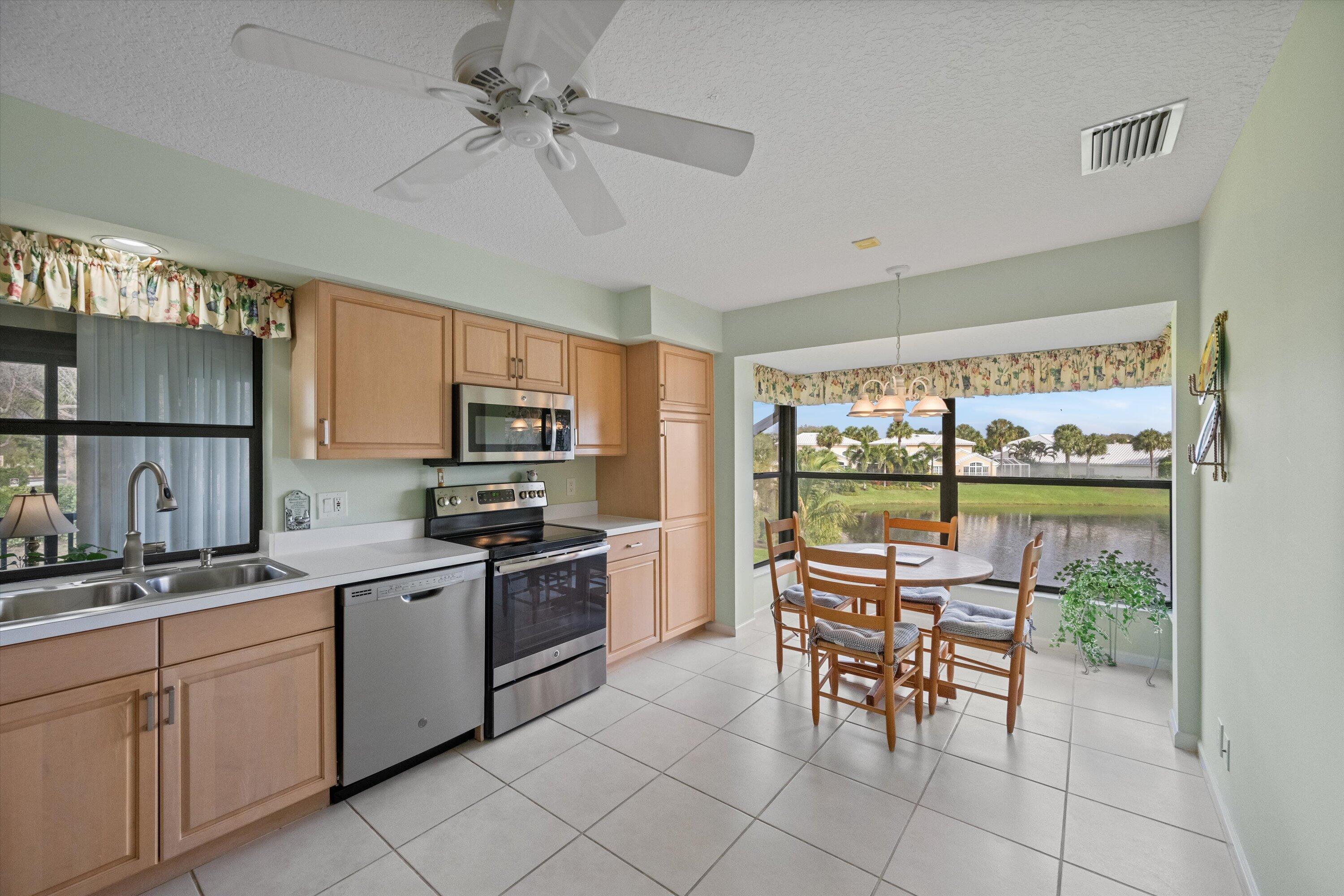 3971 Schooner Pointe Drive, Unit 201 Jupiter, FL 33477 - Photo 17 of 44 a kitchen with granite countertop cabinets and stainless steel appliances