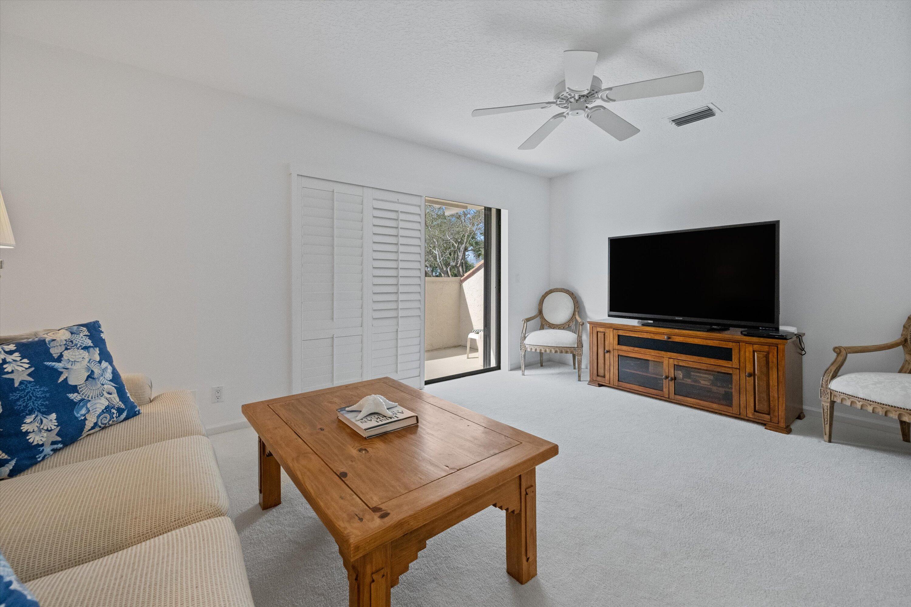 3971 Schooner Pointe Drive, Unit 201 Jupiter, FL 33477 - Photo 20 of 44 a living room with furniture and a flat screen tv