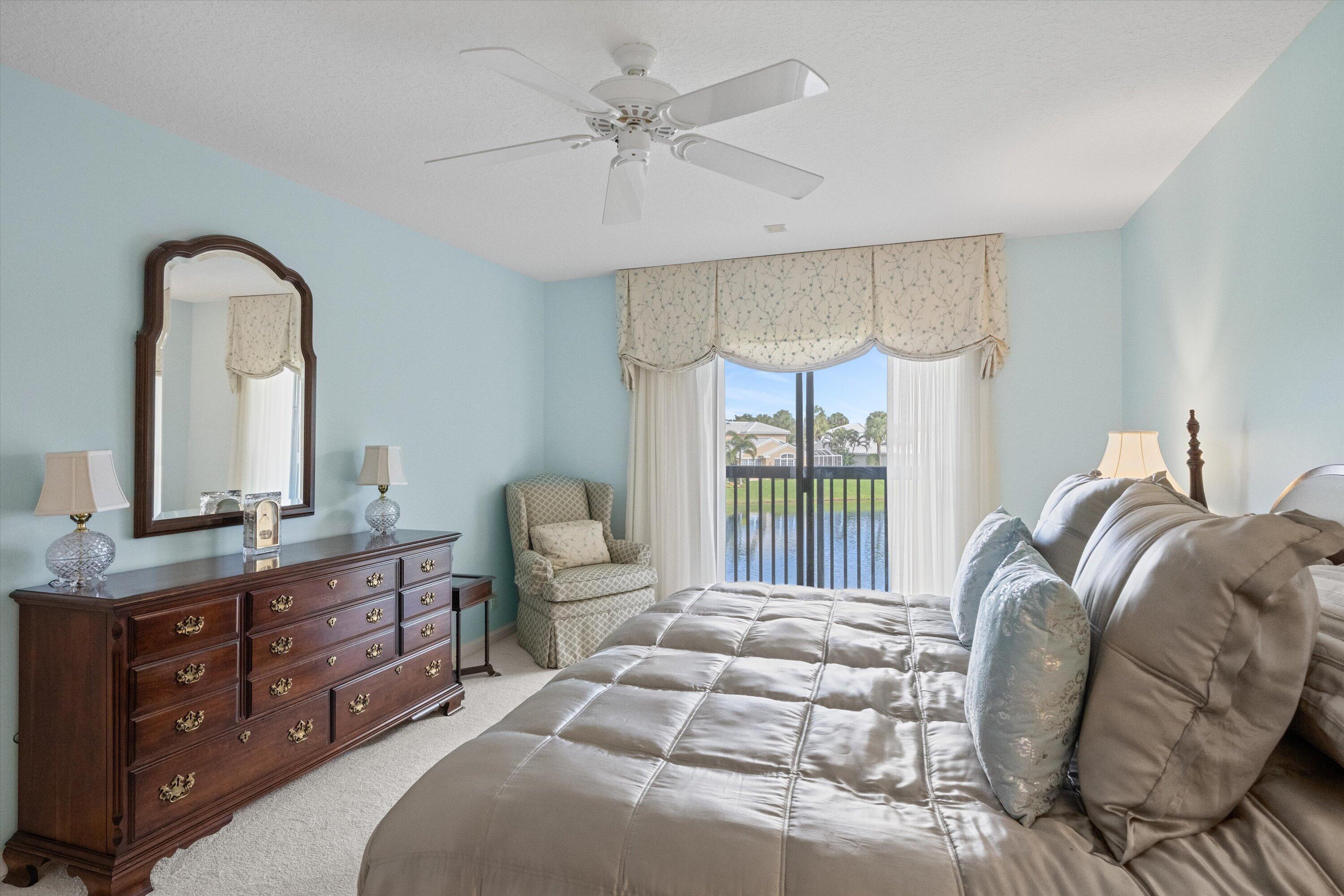 3971 Schooner Pointe Drive, Unit 201 Jupiter, FL 33477 - Photo 25 of 44 a bedroom with a large bed and a chandelier