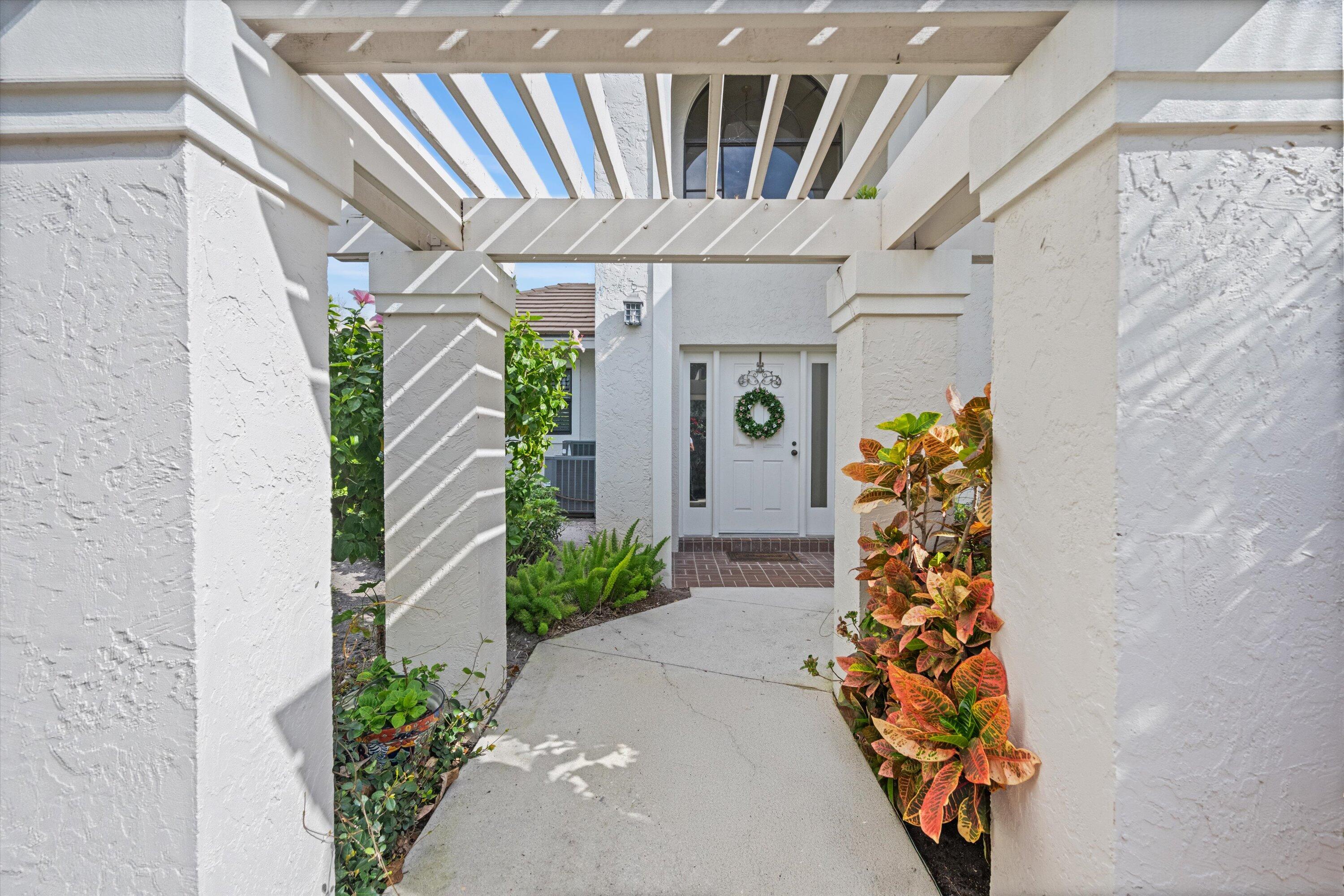 3971 Schooner Pointe Drive, Unit 201 Jupiter, FL 33477 - Photo 3 of 44 a entryway with a flower plants