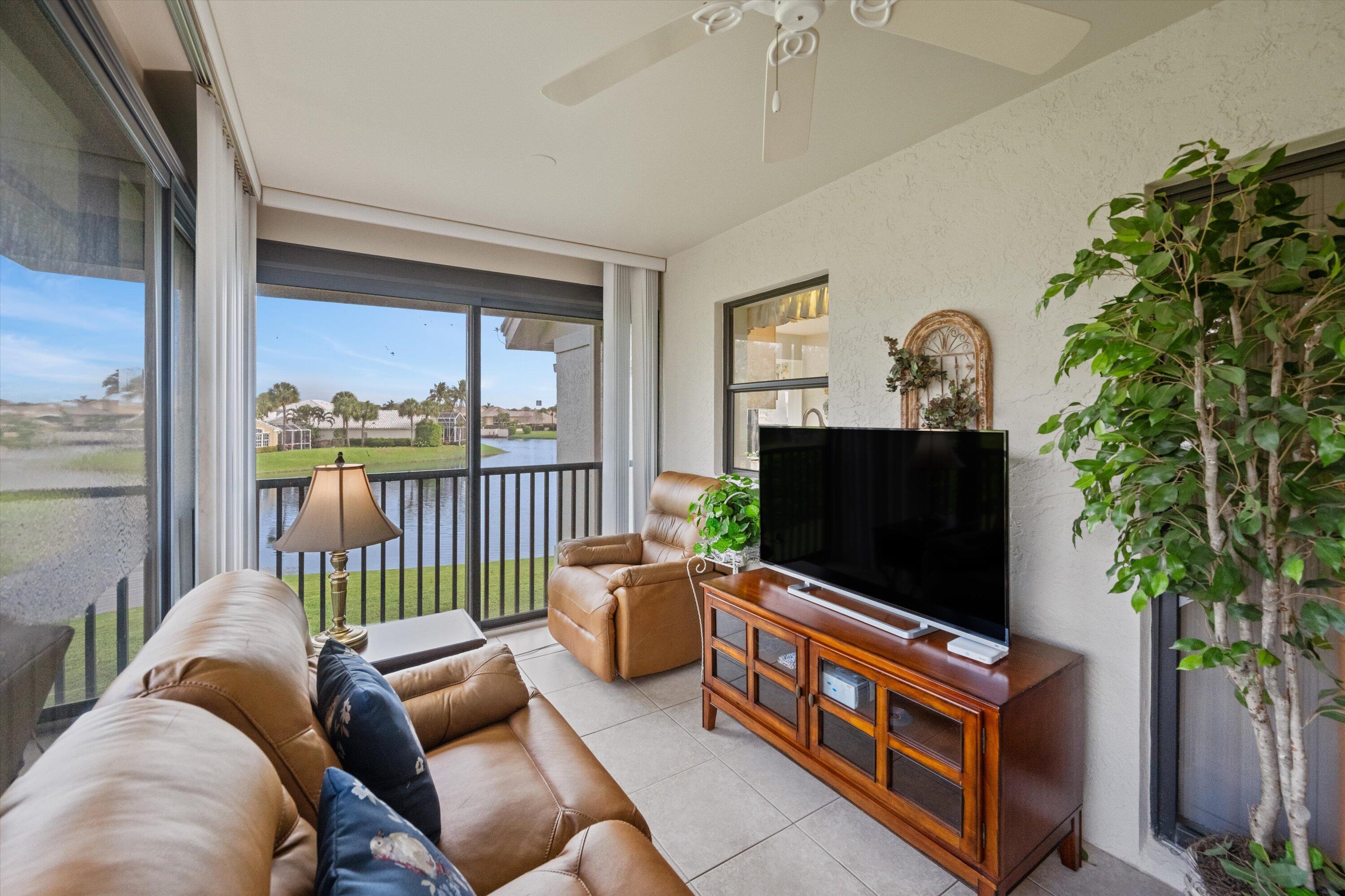 3971 Schooner Pointe Drive, Unit 201 Jupiter, FL 33477 - Photo 34 of 44 a living room with furniture and a flat screen tv
