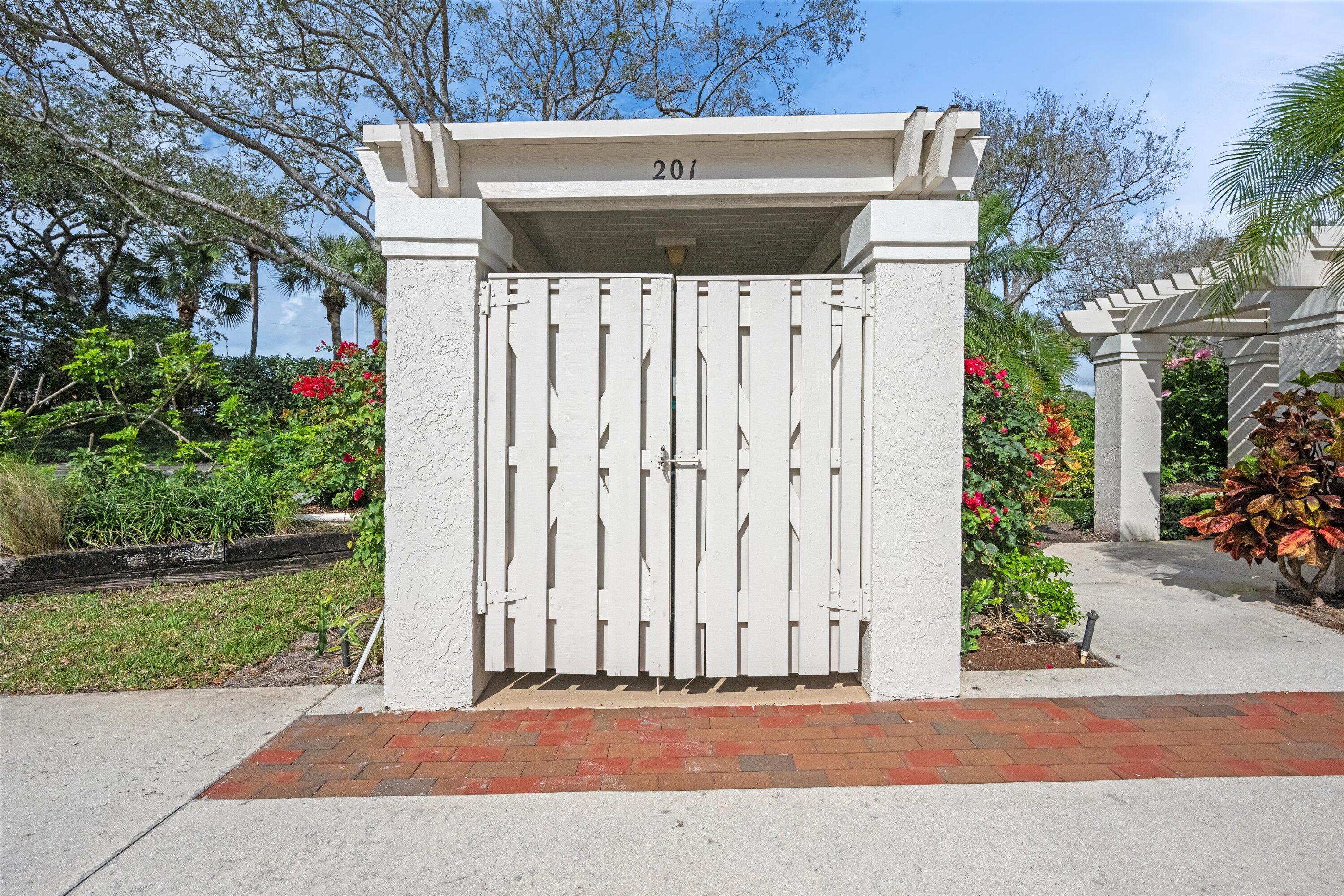 3971 Schooner Pointe Drive, Unit 201 Jupiter, FL 33477 - Photo 40 of 44 a front view of a house with a garden