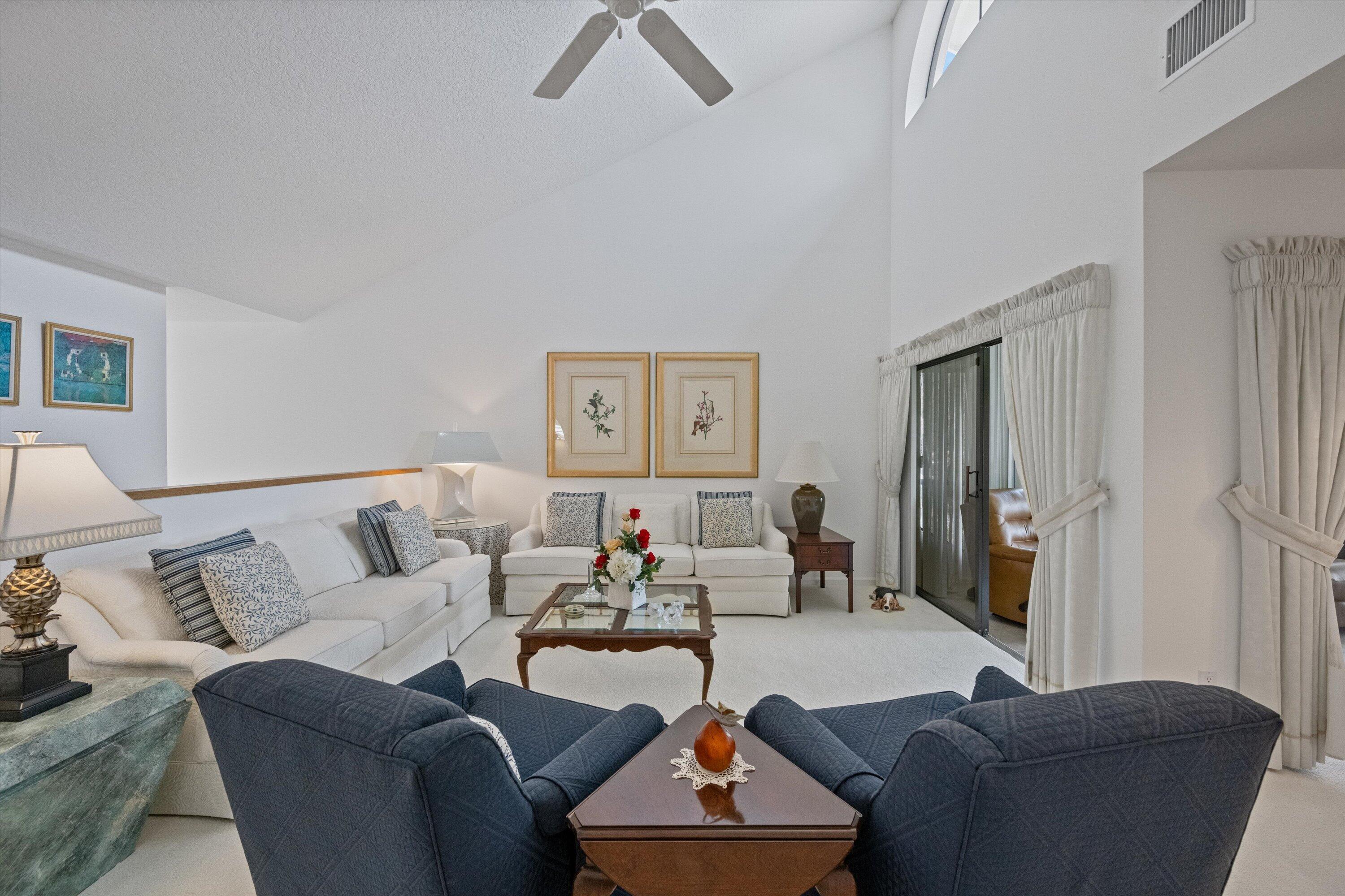 3971 Schooner Pointe Drive, Unit 201 Jupiter, FL 33477 - Photo 10 of 44 a living room with furniture and a lamp