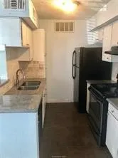 a kitchen with a sink a refrigerator and a stove