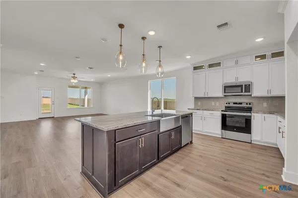 a kitchen with stainless steel appliances granite countertop a stove a sink and a refrigerator