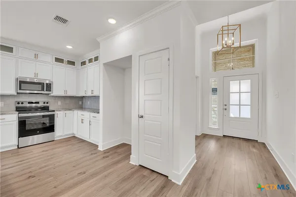 a view of kitchen with wooden floor electronic appliances and window